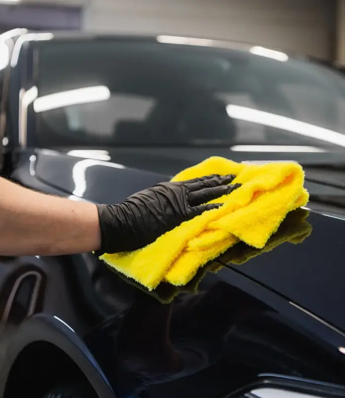 man-after-washing-wipes-black-car-with-a-rag-at-car-wash-male-hand-and-car-body-close-up